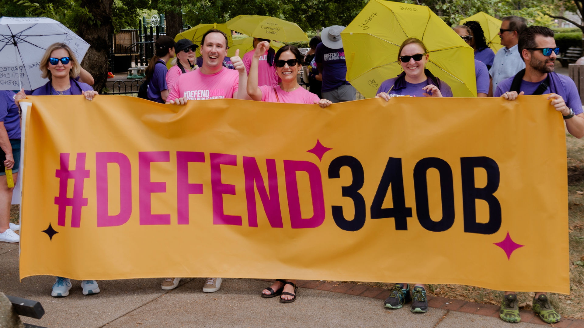 Four marchers holding a #Defend340B banner